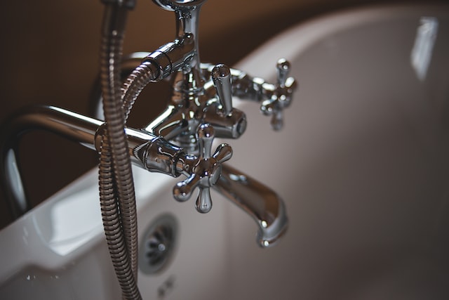 Close up of silver bathtub handles in a white bathtub